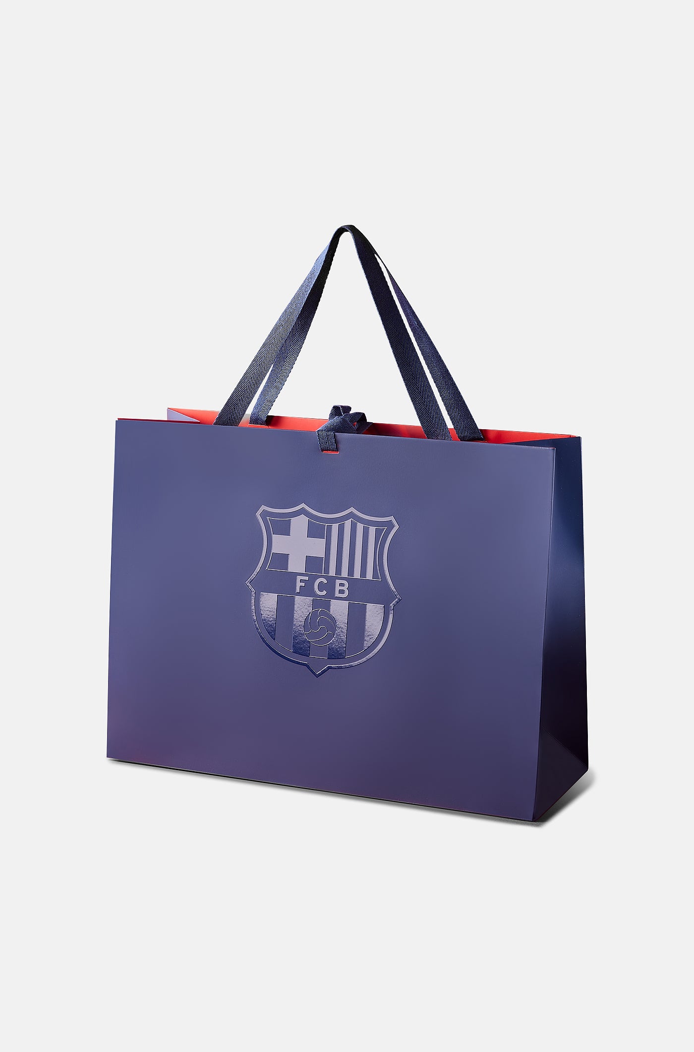 Dark blue FC Barcelona gift bag with glossy club crest on the front and dark blue handles, featuring a red interior.
