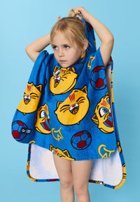 Child holding a blue towel with cartoon cat designs against a blue background