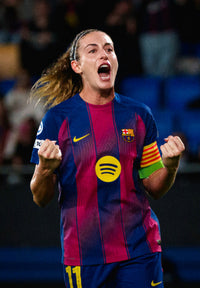 Person wearing a Barcelona soccer jersey with a Spotify logo, celebrating on a sports field.