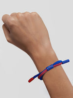 Braided bracelet in classic FC Barcelona colors—deep blue and vibrant red—featuring a subtle yet bold contrast that reflects the club’s identity. The design includes a small clasp or knot detail in the center, reinforcing the sporty and casual aesthetic. It's a minimal but expressive accessory, perfect for fans who want to wear their passion in a subtle, stylish way.
