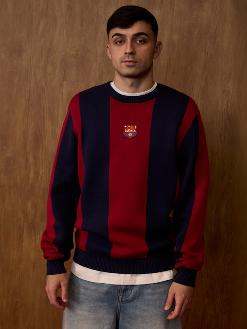 Front view of a FC Barcelona sweater worn by a model, with wide navy and garnet vertical stripes and the club crest centered on the chest.