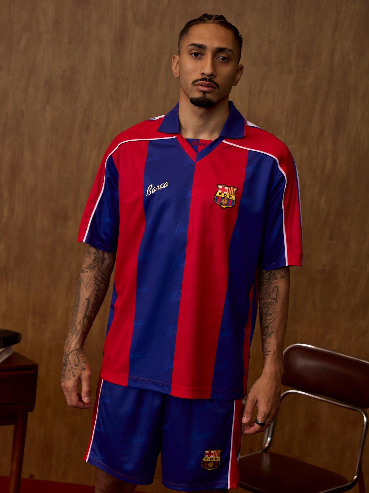 Vue de face d’un mannequin portant le maillot domicile de FC Barcelona et le short assorti à rayures verticales rouges et bleues.