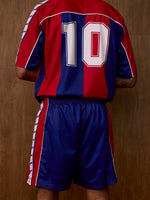 Vue de dos d'un maillot FC Barcelona à rayures rouges et bleues avec le numéro 10 et un short bleu assorti.