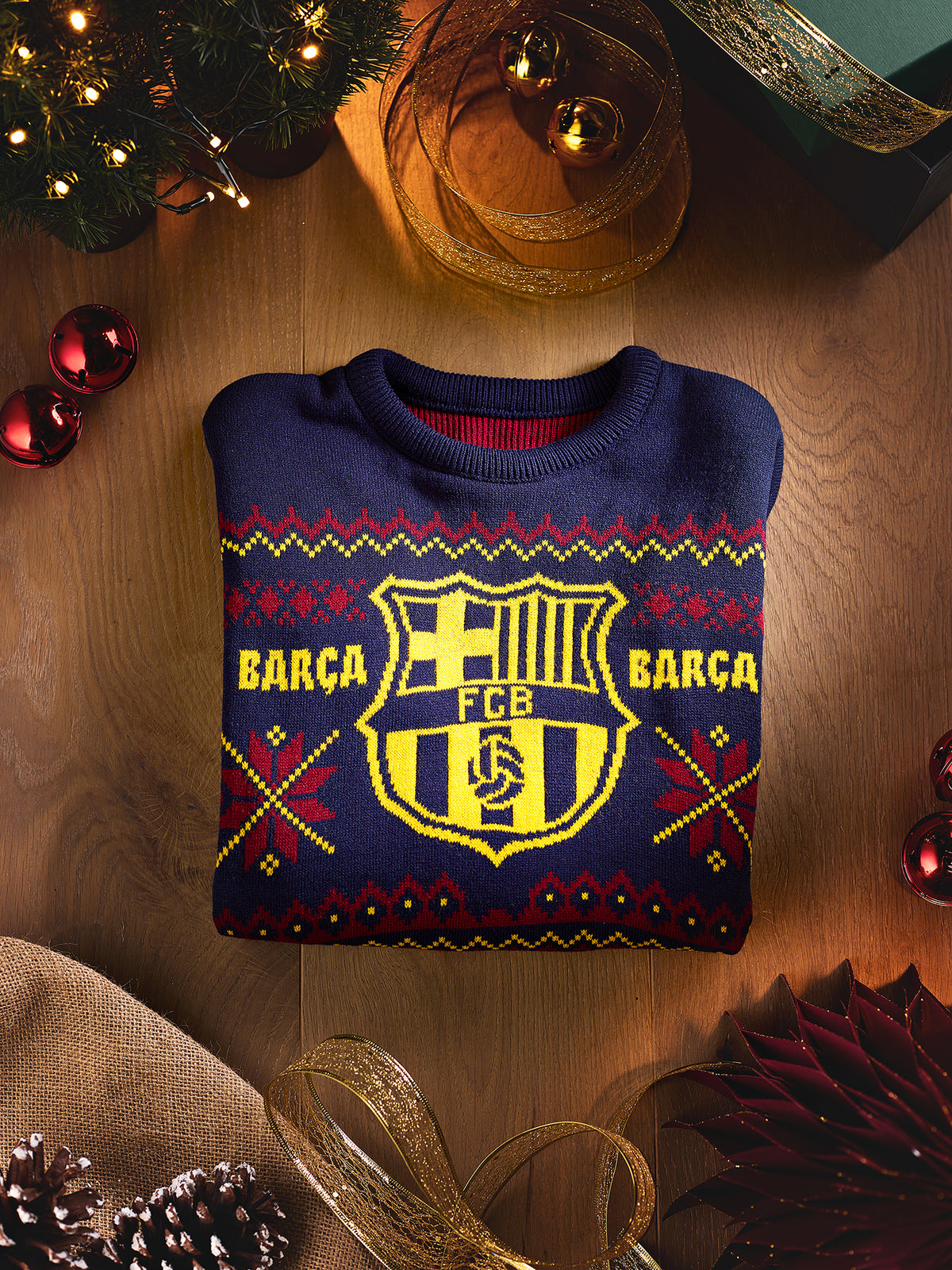 Jersey azul marino de FC Barcelona doblado, con un gran escudo amarillo del Barça y un motivo de punto rojo y amarillo en la parte frontal.