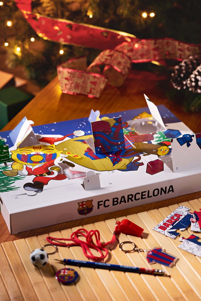 Open FC Barcelona advent calendar box with numbered holiday panels and Barça-themed accessories laid out beside it.
