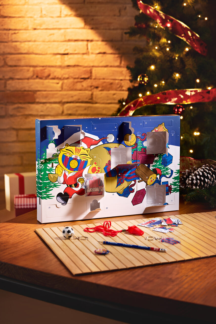 FC Barcelona advent calendar box with numbered doors and a festive Barça character illustration on a Christmas table.