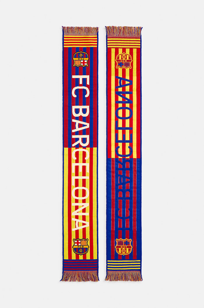 Double-sided FC Barcelona scarf in red, yellow, and blue stripes, featuring the club crest and bold white text reading 'FC BARCELONA