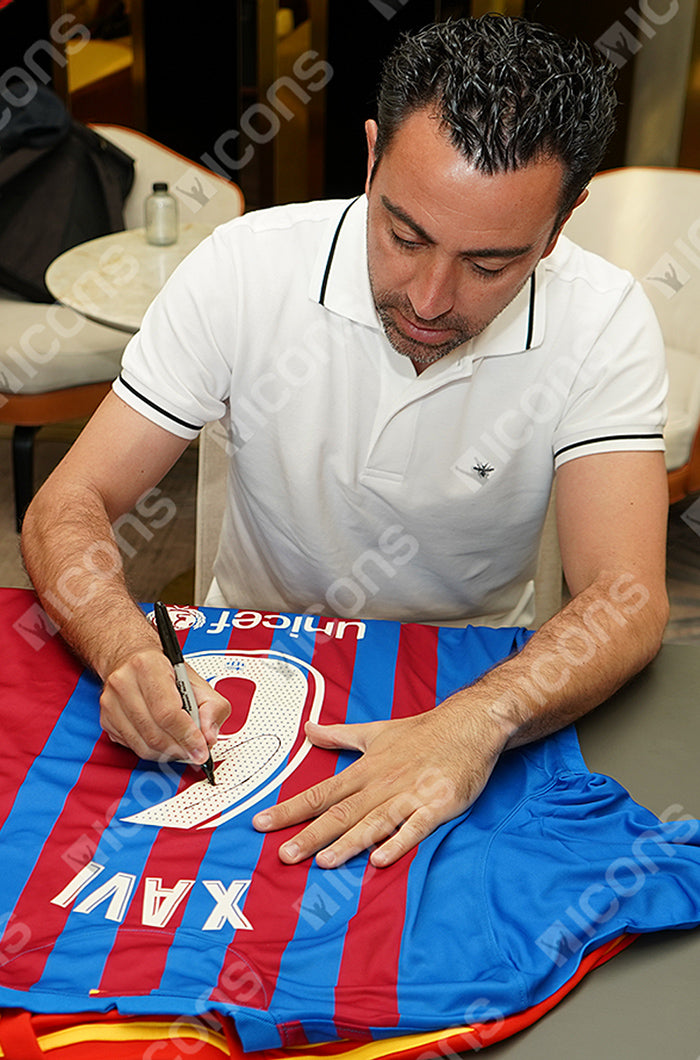 Framed FC Barcelona jersey signed by Xavi, displayed with a photo of him and official certification.