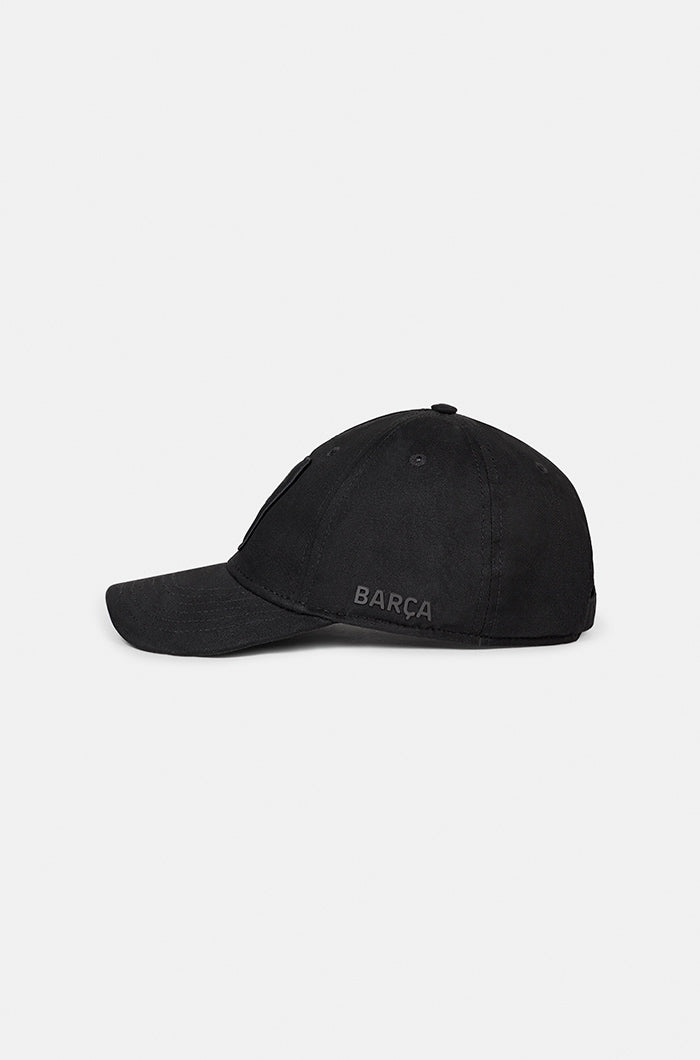 Black FC Barcelona baseball cap with a matte black crest patch on the front and the word "BARÇA" embroidered on the side, featuring a curved brim and structured fit.