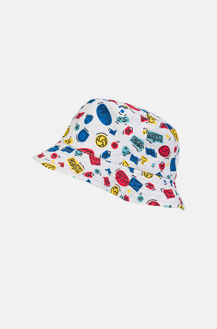 White FC Barcelona bucket hat with an all-over multicolor pattern featuring Barça-themed icons such as balls, crests, and the club name in red, blue, and yellow.