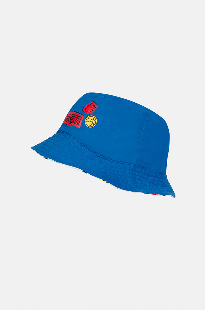 Blue FC Barcelona bucket hat with minimal embroidered graphics on the front, including a red crest, yellow football, and the word "Barça" in red.


