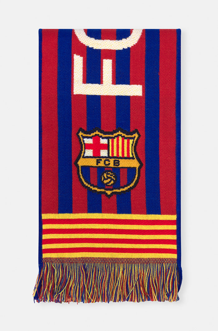 Double-sided FC Barcelona scarf in red, yellow, and blue stripes, featuring the club crest and bold white text reading 'FC BARCELONA