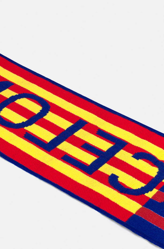 Double-sided FC Barcelona scarf in red, yellow, and blue stripes, featuring the club crest and bold white text reading 'FC BARCELONA